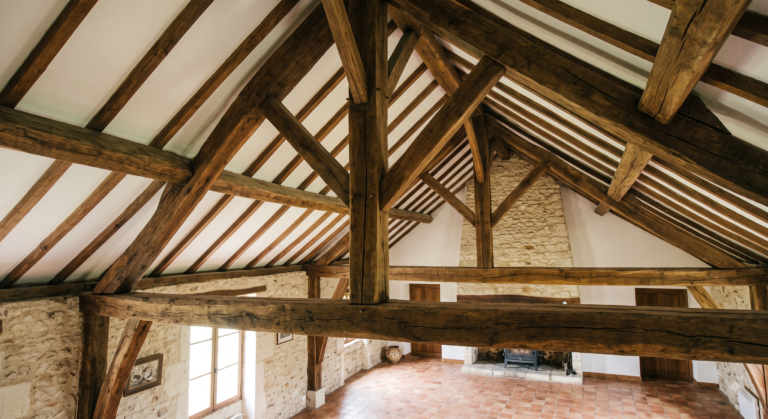 charpente en chêne apparente dans un séjour de maison ancienne, sans faux plafond pour passer des gaines de ventilation.