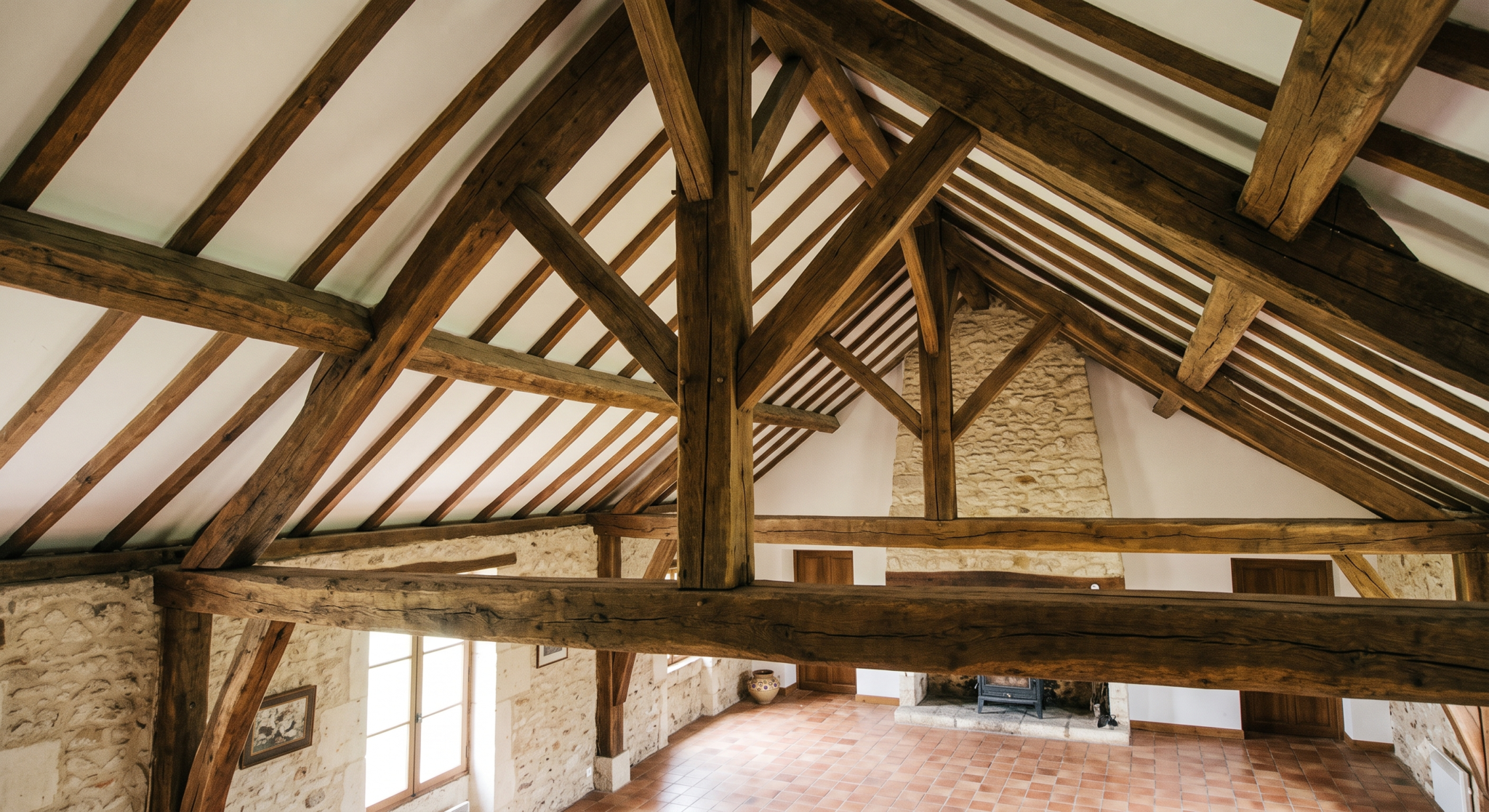 charpente en chêne apparente dans un séjour de maison ancienne, sans faux plafond pour passer des gaines de ventilation.